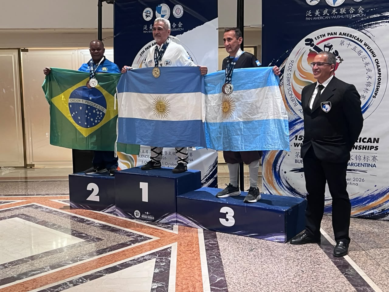 Mestre Betinho no segundo lugar do pódio, com a bandeira brasileira